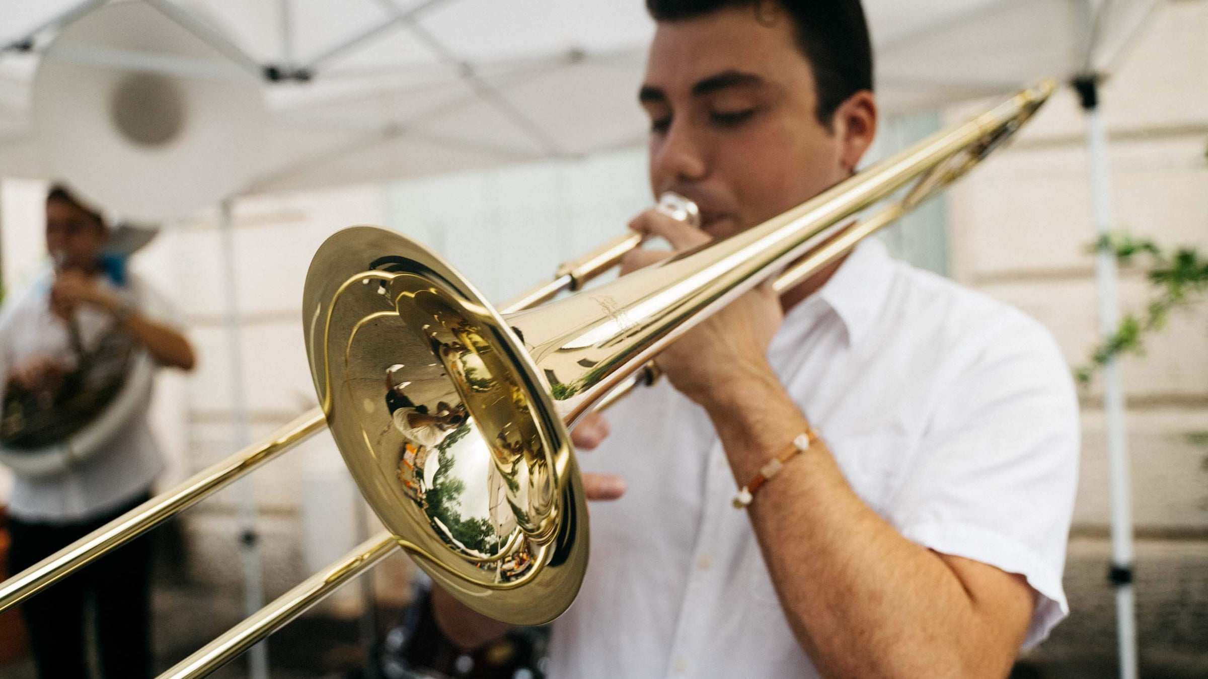 Musician playing trombone outside.